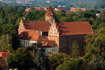 Fototapeta na wymiar Top view of the medieval gothic castle in Olsztyn against the background of forests and sky