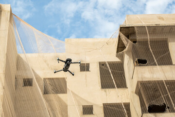 a drone flying next to building under construction