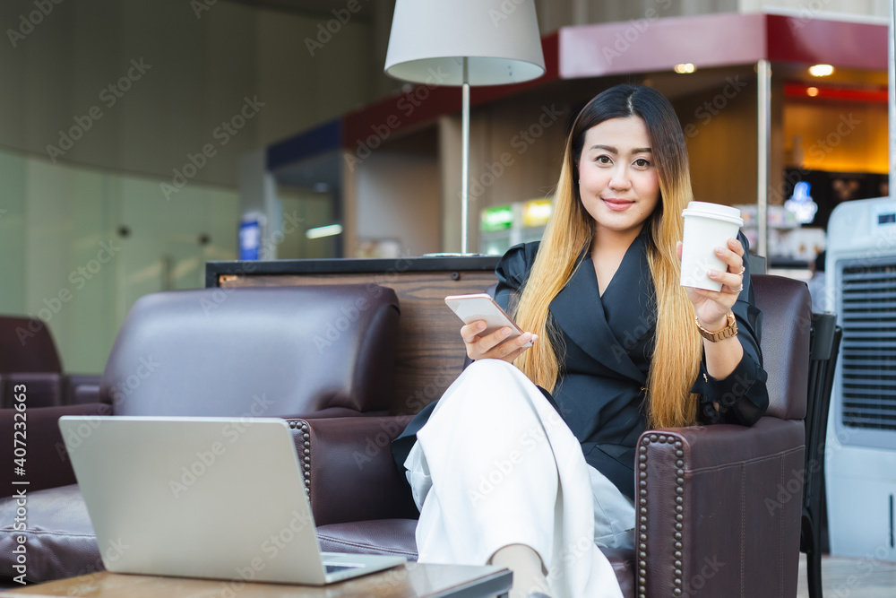 Poster asian businesswoman wear black suit holding smartphone and paper coffee cup sitting in cafe, woman l