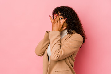 Young african american afro woman isolated blink through fingers frightened and nervous.