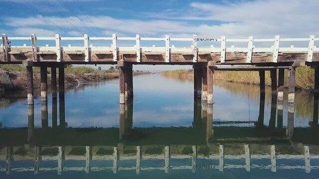 Bridge over river in farmland, slow motion 