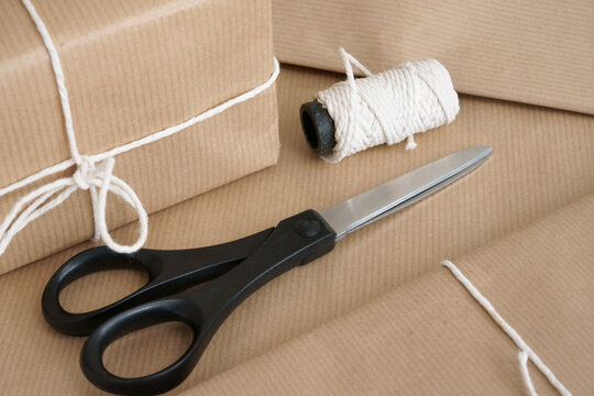 Parcel packing with brown parcel paper scissors and string