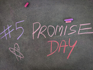 The inscription text on the grey board, #5 Promise day with hand drawn symbol . Using color chalk pieces. Valentines week