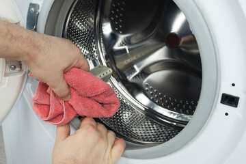 men's hands clean the washing machine