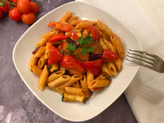 Classic, vegetable penne pasta with red bell pepper, zucchini, eggplant, tomatoes and parsley in tomato sauce.