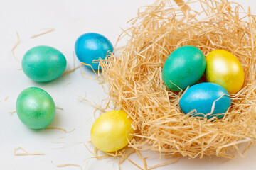 Fototapeta na wymiar Bright Illuminating multi-colored easter eggs in a nest basket