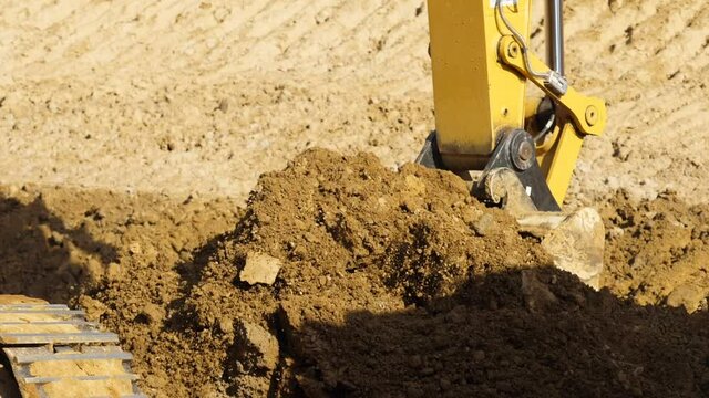 Yellow excavator digging the ground in slow motion, Close up