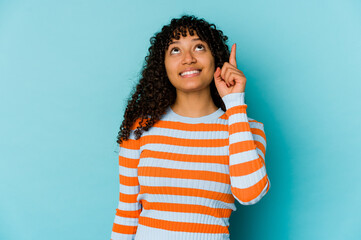 Young african american afro woman isolated indicates with both fore fingers up showing a blank...
