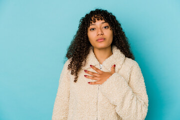 Young african american afro woman isolated taking an oath, putting hand on chest.