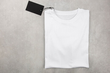 White womens cotton Tshirt mockup with label. Design t shirt template, print presentation mock up. Top view flat lay. Concrete stone background.