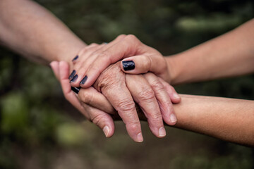 Elderly care. Holding hands old and young person