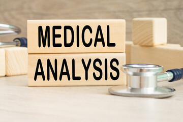 the word MEDICAL ANALYSIS is written on a wooden cubes structure . Cube on a bright background. Can be used for Medical concept. the medicine.