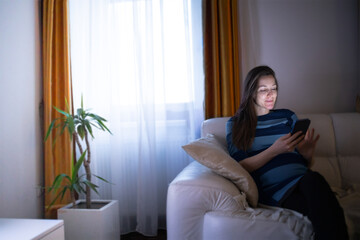 Female browsing her smart phone in her cozy apartment during the evening