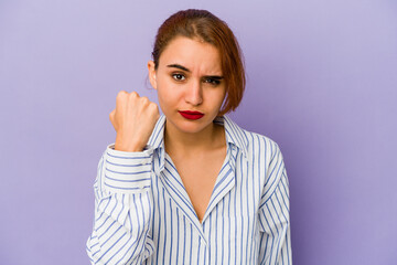 Young arab mixed race woman showing fist to camera, aggressive facial expression.