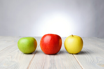 three colorful apples on table