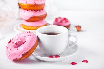 Cup of coffee and pink doughnuts on the white background. Valentine's Day concept.