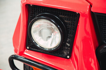 headlights of a retro vintage car in red in a showroom.