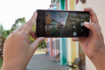 Asian woman taking photo colorful old city by smartphone