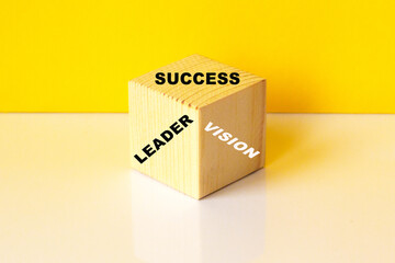 THE TEXT LEADER ,SUCCESS, VISSION ON THE CUBE. YELLOW BACKGROUND. you can use in business, marketing and other concepts.