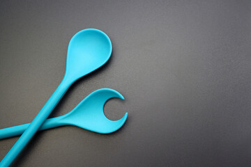 Blue bamboo spoon for salad on a bright gray  background.