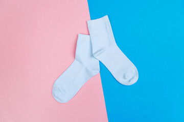 multicolored jersey socks on a pastel pink and blue background. view from above