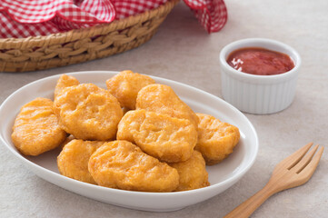 Chicken nuggets with  ketchup sauce on table.