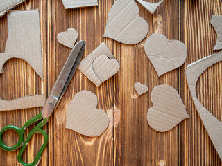 Scissors, cardboard.The process of cutting hearts out of cardboard.
