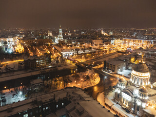 Winter night lights illuminated city aerial view. Holy Annunciation Cathedral, Dormition Cathedral, Serhiivskyi Maidan, Lopan river in Kharkiv, Ukraine