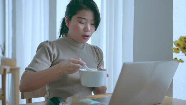 attractive asian female use laptop working online conference meeting social distancing new normal working lifestyle,asian woman working near big glass window morning time