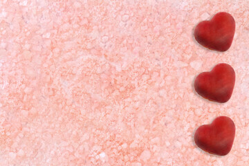Beige pink background with three hearts. Sea salt. Texture. spa backdrop. St. Valentine day. Copy space