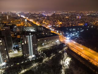 Kharkiv city center drone view on Nauky avenue. Botanical garden Sarzhyn Yar and multistorey modern high buildings at night. Aerial view on city lights streets