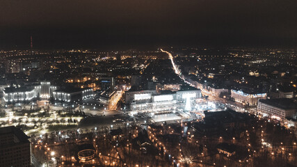 Freedom Svobody Square (Kharkiv) aerial view at night with New year holidays and Christmas tree decorations with colorful illumination in city center. Color graded