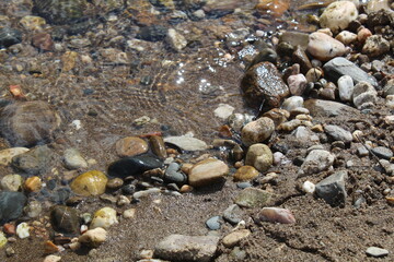 Foto que demonstra a natureza, de uma praia fluvial no verão , onde encontramos pedra/seixo/rocha 