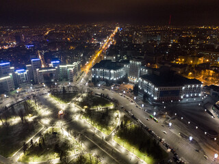 Fototapeta na wymiar Aerial night view on Freedom Svobody Square in illumination lights circus. Derzhprom and Karazina National University in Kharkiv city center, Ukraine