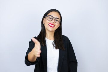 Beautiful business woman smiling friendly offering handshake as greeting and welcoming