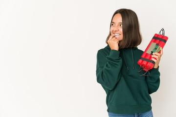 Young hispanic woman holding dynamite relaxed thinking about something looking at a copy space.