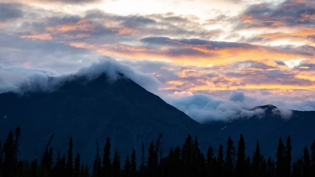 Time Lapse. Beautiful View of Canadian Nature with Mountains in the Background. Cloudy Sunset. Kathleen Lake, Kluane National Park, Yukon, Canada. Pan Right