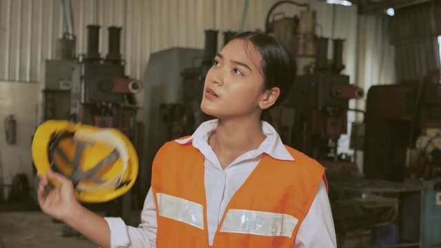 Tired woman worker Asian labor hard work in hot factory wiping away sweat