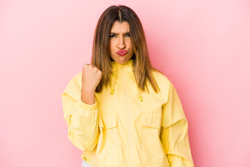 Fototapeta premium Young indian woman isolated on pink background showing fist to camera, aggressive facial expression.