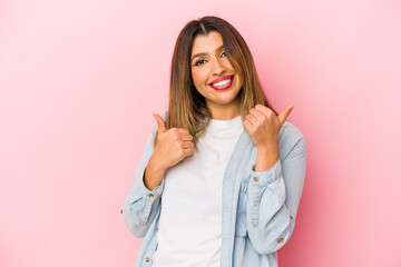 Young indian woman isolated on pink background raising both thumbs up, smiling and confident.