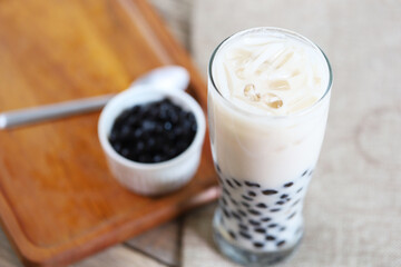 fresh ice milk tea in the glass with bubble boba and refill boba in the littel bowl 