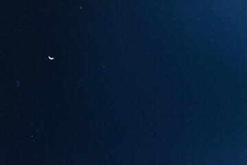 Obraz na płótnie Canvas The stars and the moon shining in the night sky.