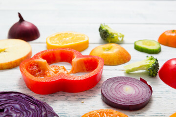 sliced fruit and vegetable circles on white wood table