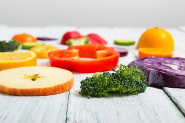 sliced fruit and vegetable circles on white wood table