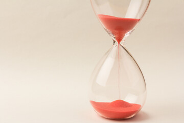 Crystal hourglass on champagne background as a concept of passing time for business term, urgency...