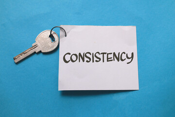 Consistency is the key, text words typography written on paper against blue background, life and...