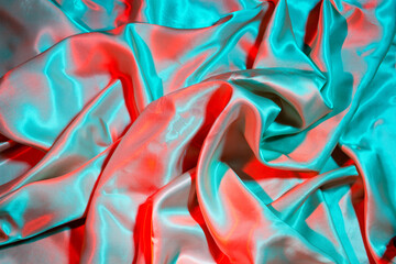 Smooth elegant Silk fabric in neon blue and red lights. Texture, background, copy space
