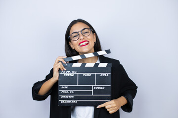 Beautiful business woman holding a clapperboard