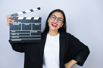 Beautiful business woman holding a clapperboard