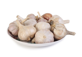 Garlic on a porcelain saucer. Isolated objects on white background
